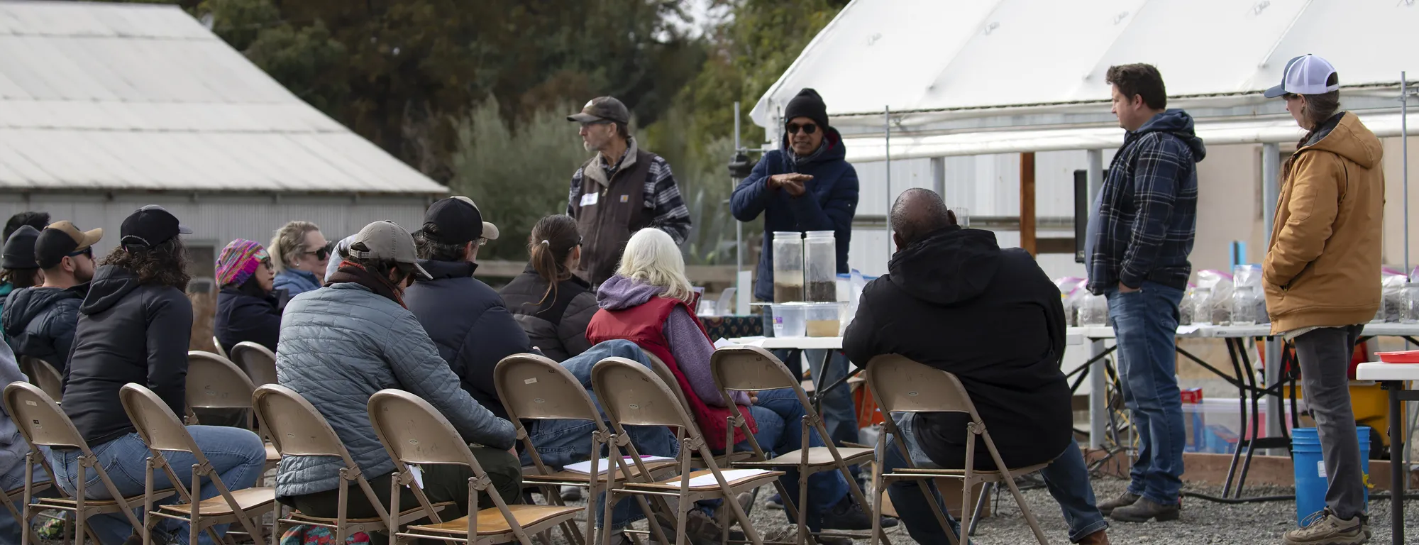 People sitting in chairs viewing soil samples during a soil structure assessment workshop