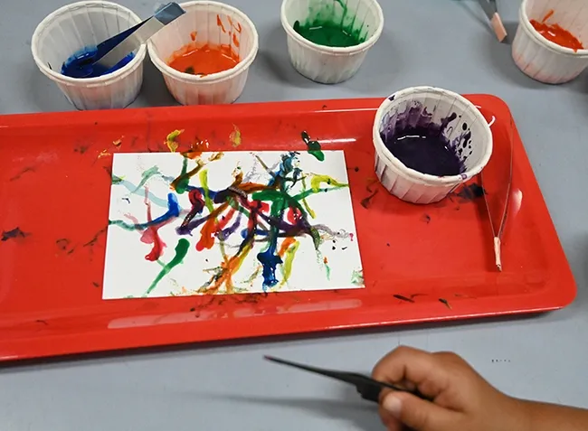 Maggot Art at the Bohart Museum of Entomology open house. Tools of the trade: maggots, water-based and non-toxic paint, paint containers, forceps, and white paper. (Photo by Kathy Keatley Garvey)