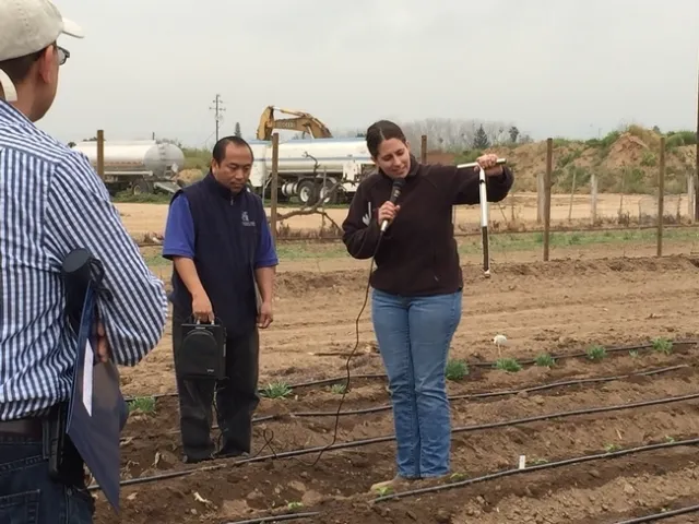 Pie de grabado “Este proyecto expandirá nuestros esfuerzos actuales para apoyar a los agricultores a pequeña escala para que tengan acceso a equipo, mercados nuevos y apoyo técnico”, mencionó Ruth Dahlquist-Willard, quien fue captada demostrando cómo evaluar la humedad de la tierra junto con Michael Yang. Fotografía por Ka Xiong