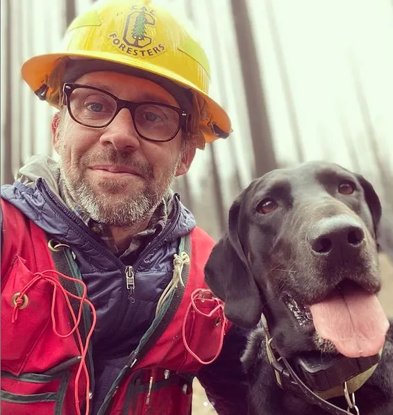 Ryan, wearing a red jacket and yellow hard hat that reads,