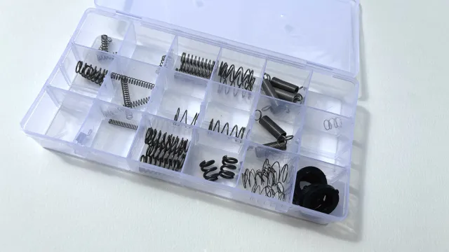 A tackle box container with assorted springs and gaskets.