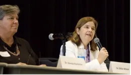 Gillian Wilson on right speaks into mic