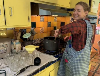 Photo of Lorie's daughter Alex boiling fruit to ladle in jars.