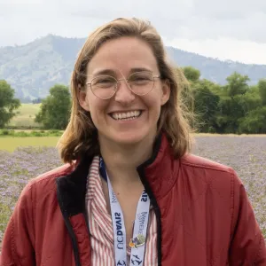 A person in a red jacket in a field of flowers.